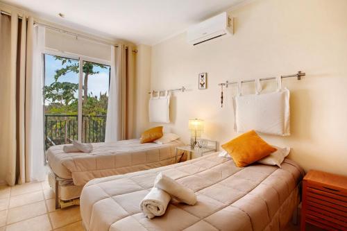 a hotel room with two beds and a window at Energia Dourada - Porto Santo in Porto Santo
