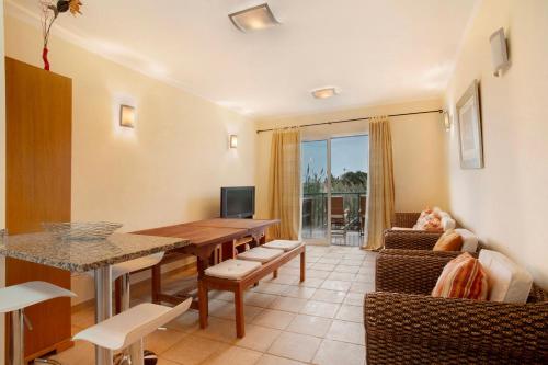 a living room with a table and a couch at Energia Dourada - Porto Santo in Porto Santo