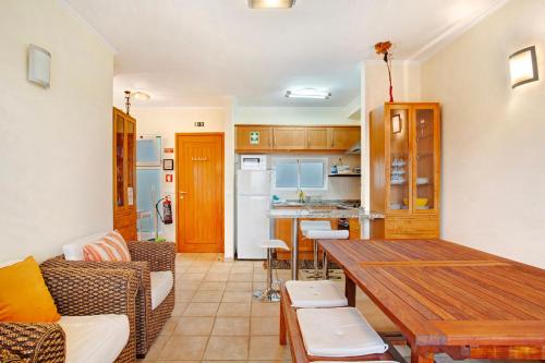 a kitchen and dining room with a wooden table at Energia Dourada - Porto Santo in Porto Santo