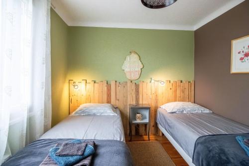 two twin beds in a room with green walls at Maloan, gite avec piscine in Saint-Julien-de-Lampon
