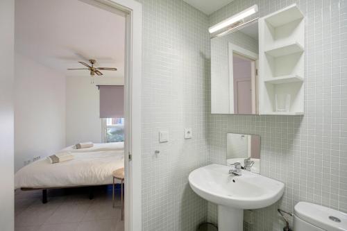 a bathroom with a sink and a mirror and a bed at Los Martínez Duplex in El Médano