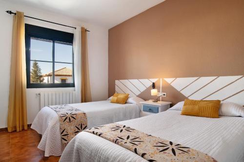 two beds in a room with a window at Casa Mia Jacuzzi Exterior in Ronda