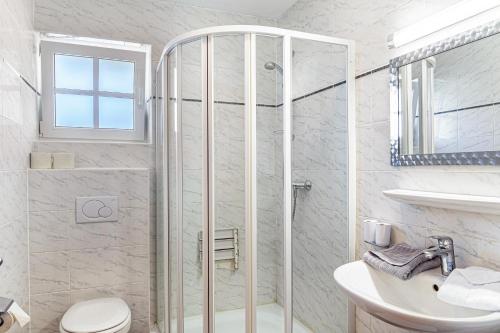 a bathroom with a shower and a toilet and a sink at Landhaus Sonja 1 in Leutasch