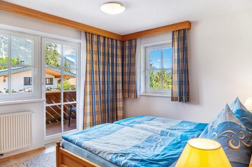 a bedroom with a bed and two windows at Landhaus Sonja 1 in Leutasch