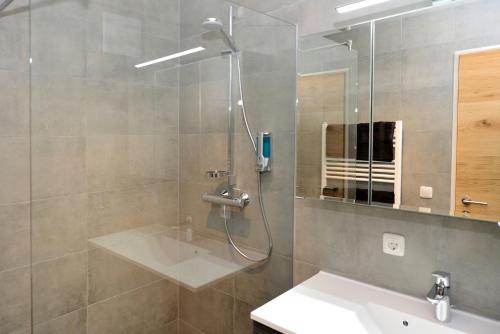 a bathroom with a shower and a sink and a mirror at Apartment Olperer in Mühlbachl