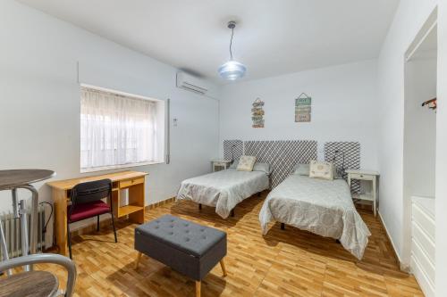 a bedroom with two beds and a desk at Alojamiento cerca de Puy de Fou in Manzaneque
