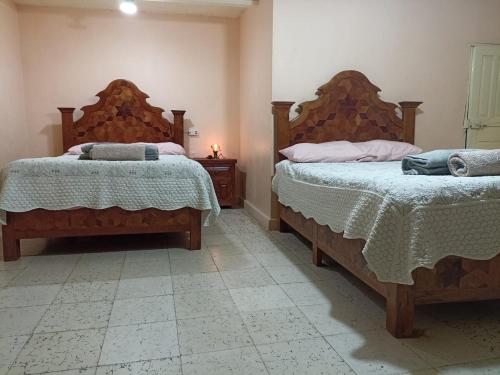 two beds in a room with two bedsitures at Tranquilidad y comodidad in Dolores Hidalgo