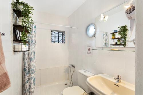 a white bathroom with a toilet and a sink at Apartamento Danoe 3 in Mogán