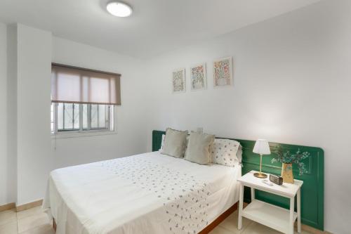 a white bedroom with a bed and a table at Apartamento Danoe 3 in Mogán
