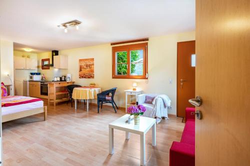 a room with a bed and a table and a kitchen at Hach in Sulzburg