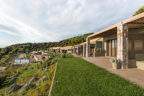 an exterior view of a house with a green yard at Elimnion Resort in Khronia