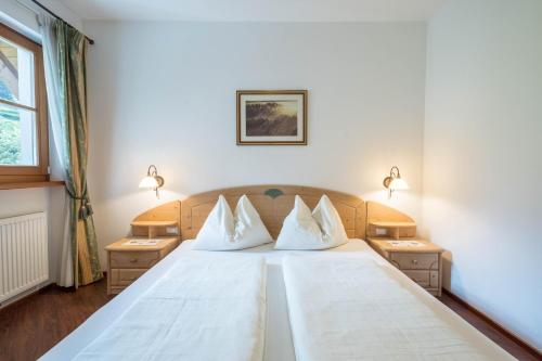 a bedroom with a large bed with white sheets and pillows at Tischlerhof - Typ B mit Terrasse in Tirolo