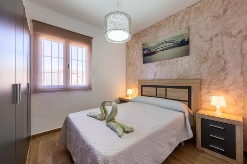 a bedroom with a bed and two windows at Citronela in Níjar