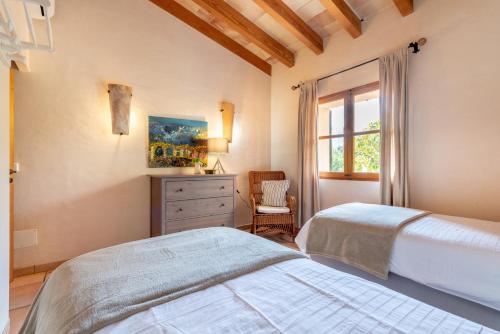 a bedroom with a bed and a dresser and a window at Finca Ca'n Vaqueta in Sóller