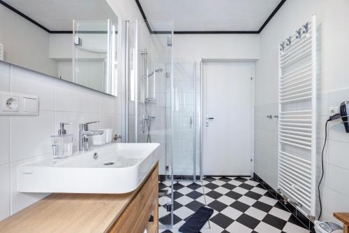 a white bathroom with a sink and a shower at Landhaus Heiddorf in Neu Kaliß