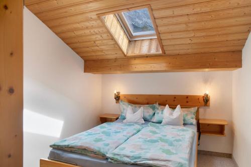 a bedroom with a bed with a wooden ceiling at Ferienwohnung Frieder in Grainau