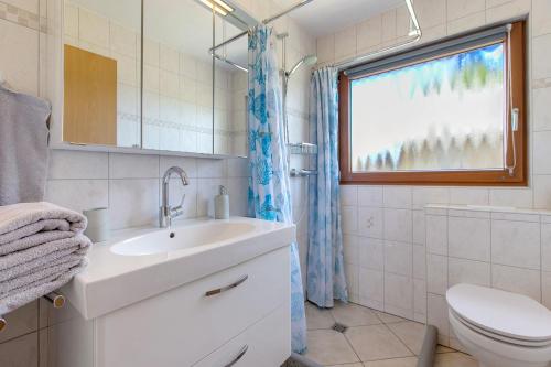 a bathroom with a sink and a toilet and a window at Auszeit an der Eider in Hennstedt
