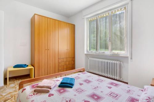 a bedroom with a bed and a wooden cabinet at Gravedona Lake Como in Consiglio di Rumo