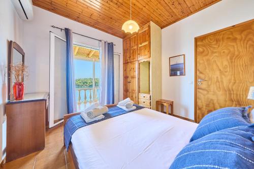 a bedroom with a large white bed and a window at Dolphin villa 1 in Gaios