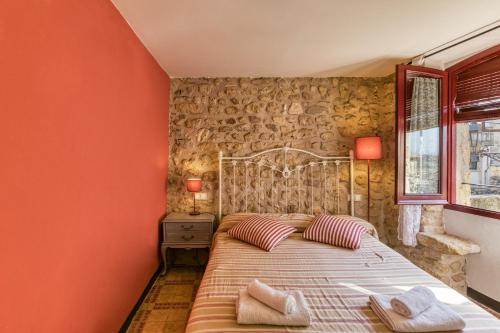 a bedroom with a bed with red walls and a window at Casa Vermella in Orriols
