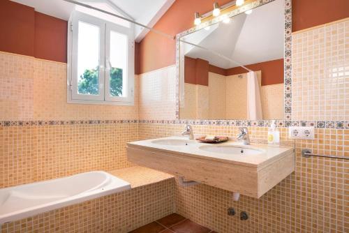 a bathroom with a sink and a tub and a mirror at Sol, playa y diversion en Roche in Roche
