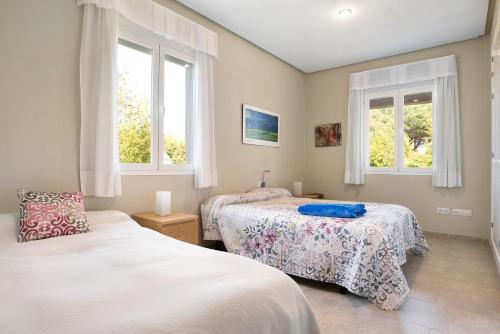 a bedroom with two beds and two windows at Sol, playa y diversion en Roche in Roche