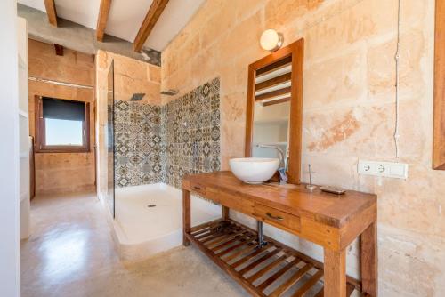 a bathroom with a sink and a mirror and a tub at Son Coranta in Campos