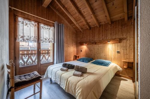 a bedroom with a large bed in a room with wooden walls at Chalet La Grangerie in Montriond