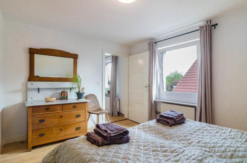 a bedroom with a bed and a dresser and a window at Landhausappartment in Bermatingen