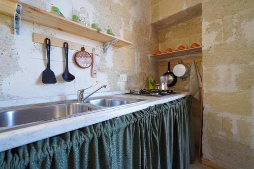 a kitchen with a stainless steel sink and utensils at La Casa di Marta in Faccia di Trippa