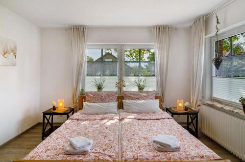 a bedroom with two beds and two windows at Haus Scheve in Rhauderfehn