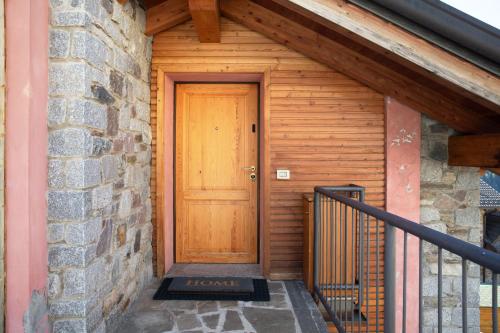 a wooden door on a building with a staircase at Il Piccolo Sogno in Temù