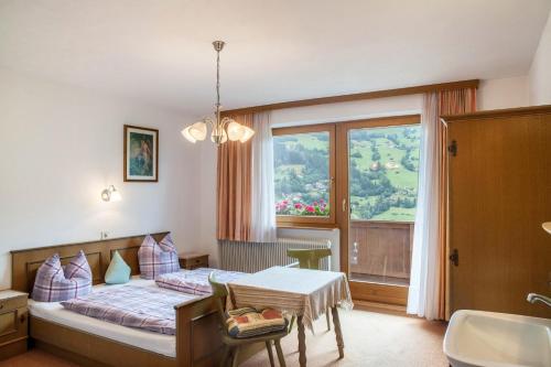 a bedroom with a bed and a table and a window at Ferienwohnung Dornauer in Hippach