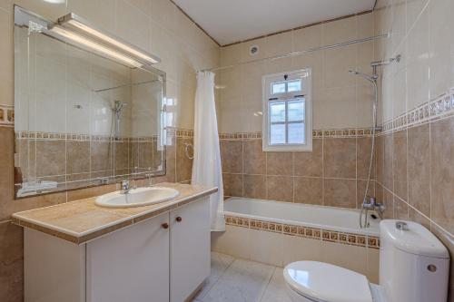 a bathroom with a sink and a toilet and a tub at Villa el Yuka , heated pool in Callao Salvaje