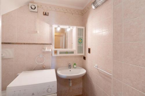 a bathroom with a sink and a washing machine at Piaz de Vich in Vigo di Fassa