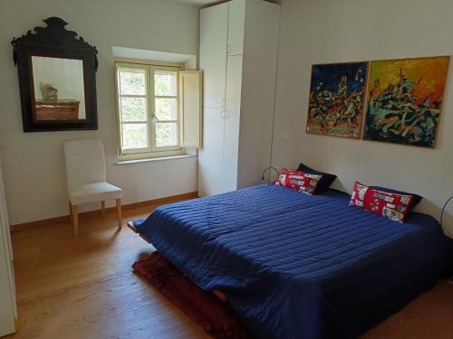 a bedroom with a blue bed and a window at Calci - dal monte al mare in Calci
