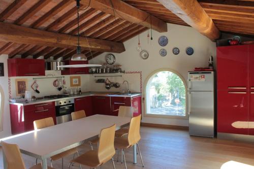 a kitchen with red cabinets and a table with chairs at Calci - dal monte al mare in Calci