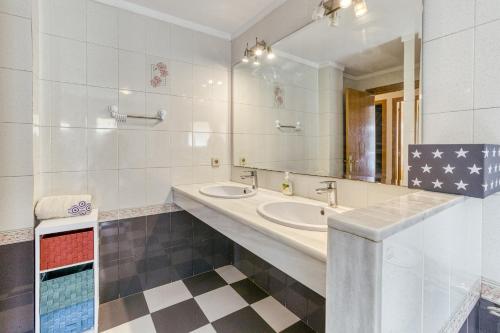 a bathroom with two sinks and a large mirror at La cargolera in L'Escala