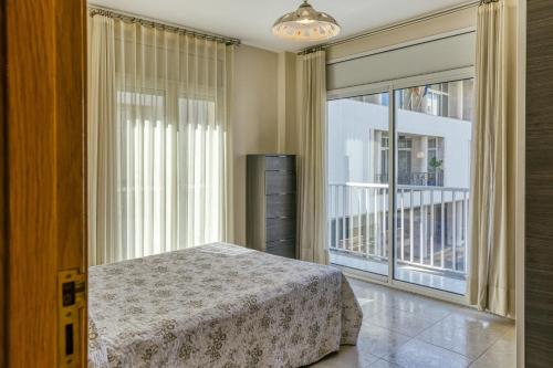 a bedroom with a bed and a large window at La cargolera in L'Escala