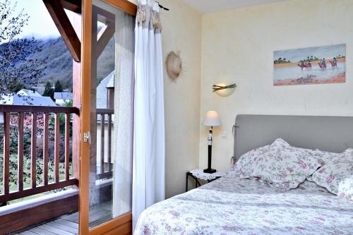 a bedroom with a bed and a balcony at Les Hélianthèmes in Guchen