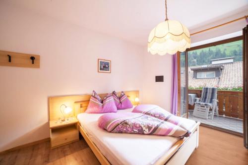 a bedroom with a bed with purple pillows at Sonnenparadies Apartement 3 in Saltusio
