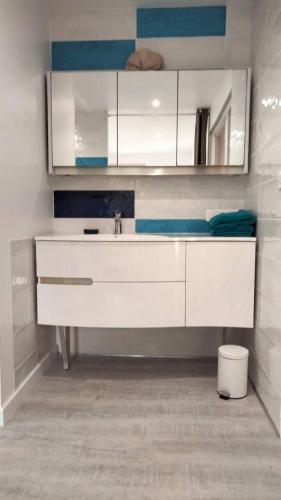 a bathroom with a sink and white cabinets at Chez Gaston in Bourges