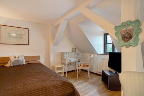 a bedroom with a bed and a desk with a television at Sechtlberggut in Plain