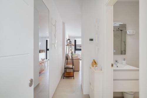 a white bathroom with a sink and a mirror at Apartamento The Stairs 2 11 in Tarifa