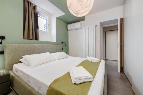 a bedroom with a bed with two towels on it at Gemhouse Smeraldo garda lake in Gargnano