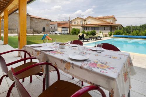 a table with a table cloth on it next to a pool at Country House - Casa Da Marquinhas in Lama de Ouriço