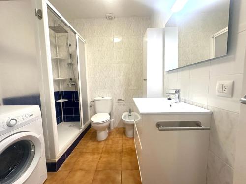 a bathroom with a toilet sink and a washing machine at White Sands 3.07 in Arenal d'en Castell