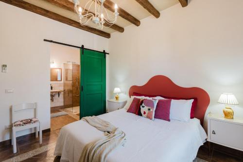 a bedroom with a large bed with a green door at Le Giarre - Villa Con Piscina in Marausa