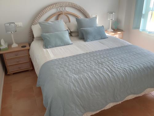 a bedroom with a large bed with blue pillows at Los Almendros in Vera