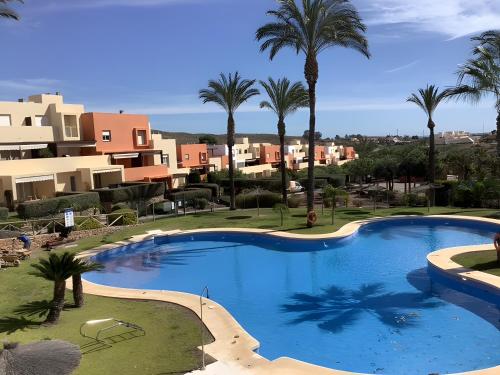 a large swimming pool with palm trees and buildings at Los Almendros in Vera